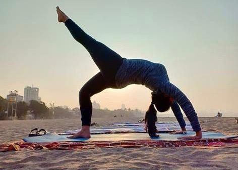person practicing yoga on the beach