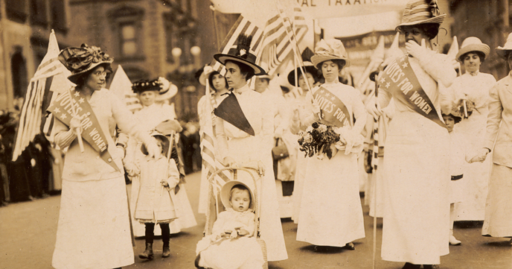 A photograph of the women's suffrage parade, showcasing activists marching for voting rights.