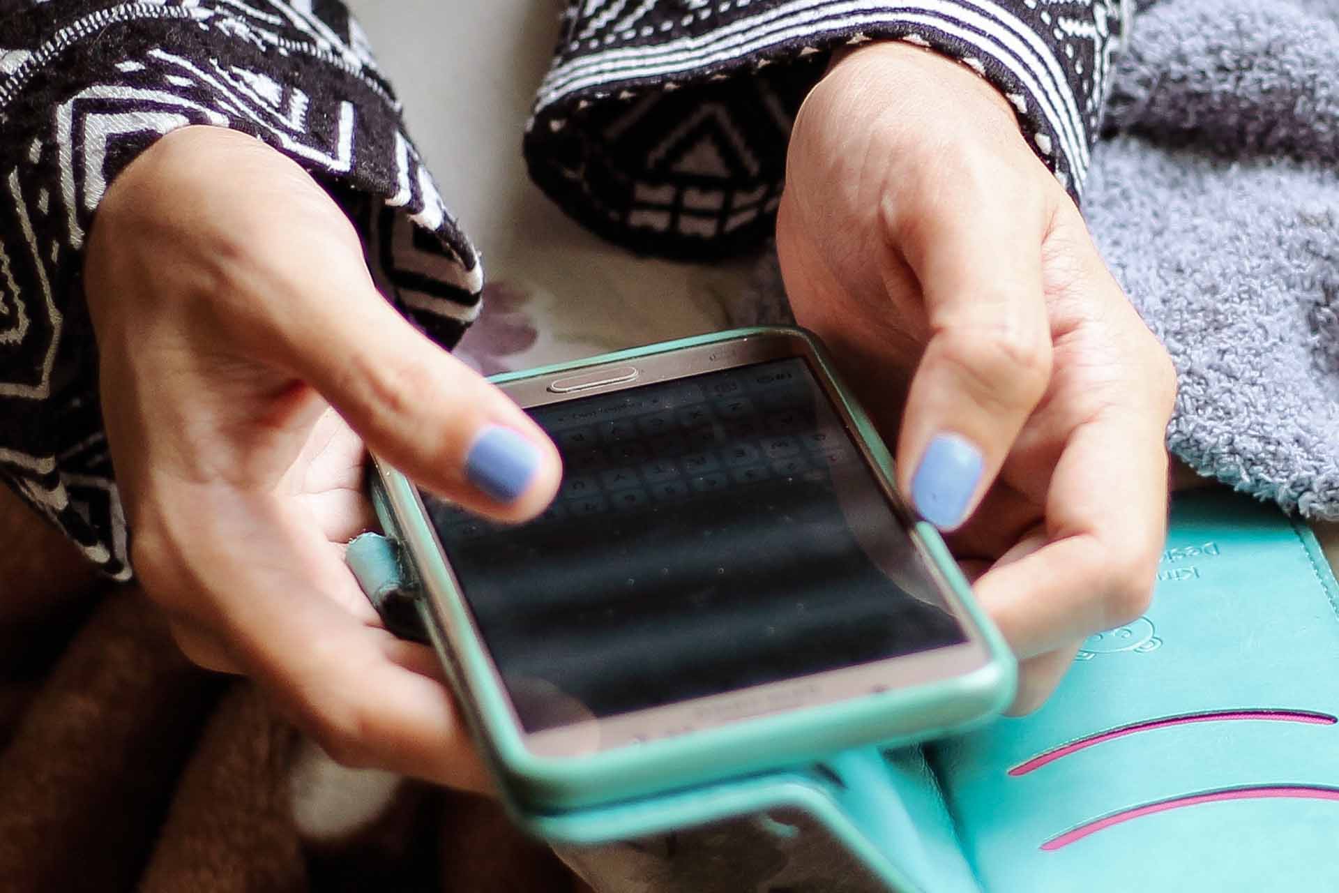 A person holding and browsing through their phone.